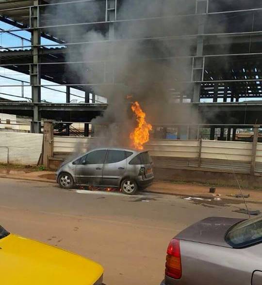 Une voiture en feu devant la Sopecam à Yaoundé